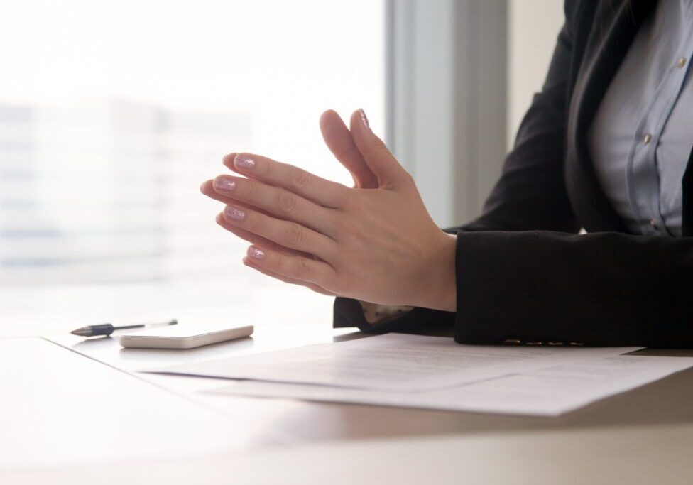 Close up view of female hands put together as in prayer in the office. Focused concentrated job applicant is nervous waiting for interview, businesswoman collecting thoughts before important meeting