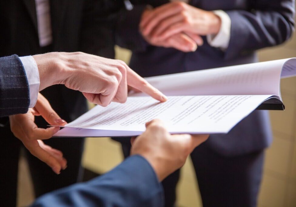 Cropped view of businesswomen reading document. Closeup shot of female finger pointing at page. Business concept