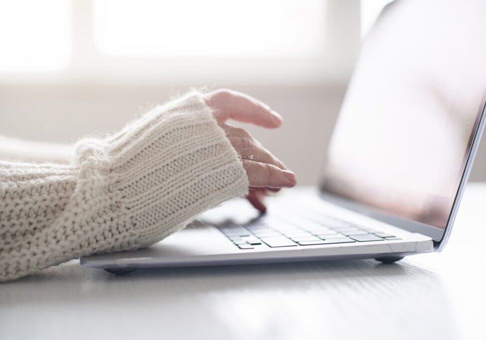 Female hands using laptop keyboard closeup. Home office concept